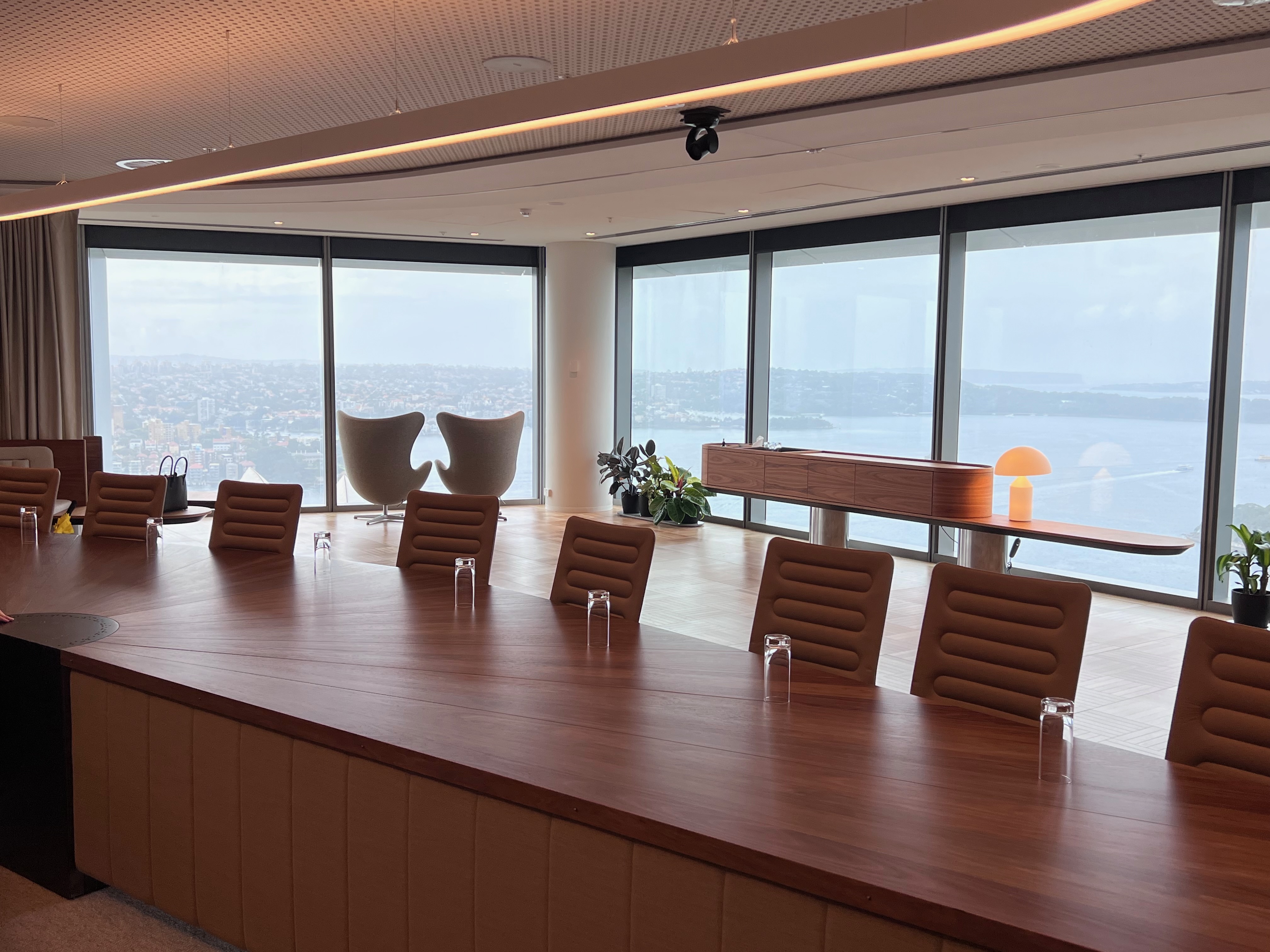 Photo of a board room table with a view across Sydney harbour in the background.